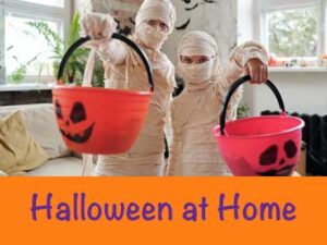 Halloween at home two kids dressed as mummys holding trick or treat pails